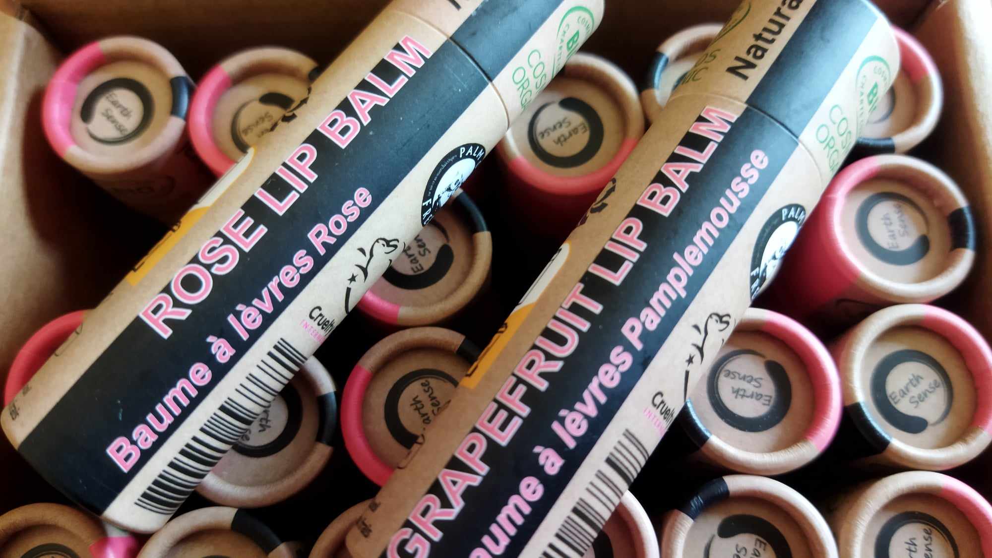 A collection of 30 tubes of 15ml Organic Rose Lip Balm, showcasing their eco-friendly packaging and natural ingredients.