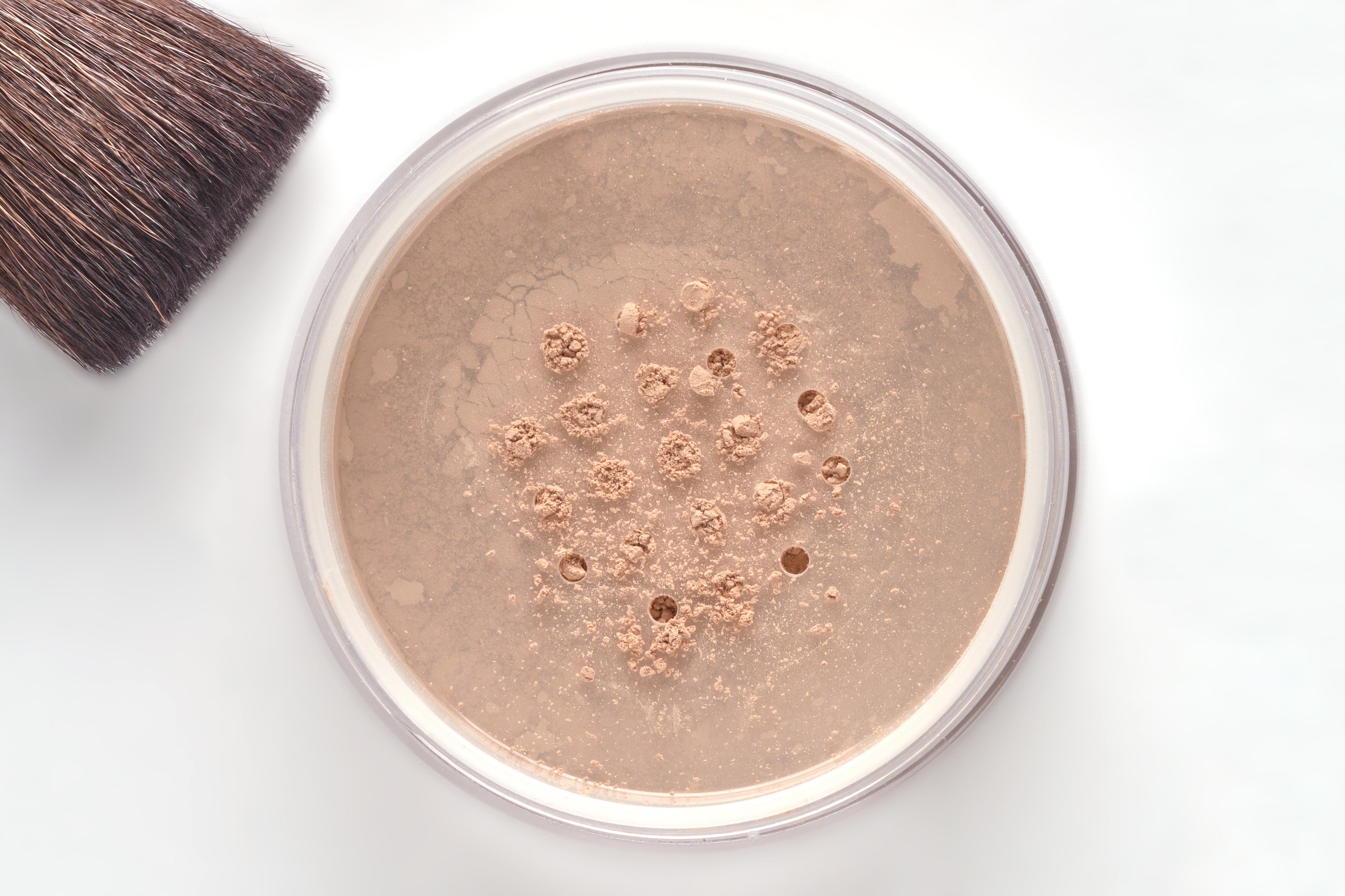 A jar of Mineral Loose Powder showcasing its fine texture and lightweight formula, ideal for normal to oily skin types.