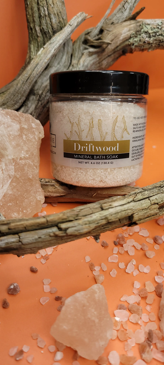 A jar of Mineral Soak - Driftwood bath salt, featuring a blend of Himalayan pink salt, Dead Sea salts, and Pacific solar salts, with a calming driftwood fragrance.