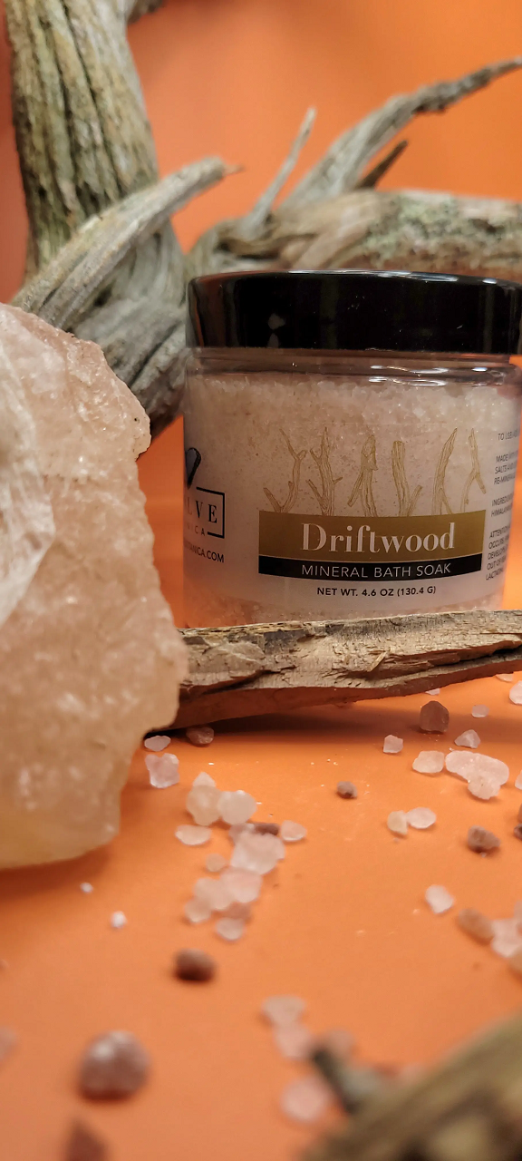 A jar of Mineral Soak - Driftwood bath salt, featuring a blend of Himalayan pink salt, Dead Sea salts, and Pacific solar salts, with a calming driftwood fragrance.