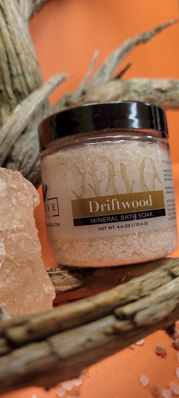 A jar of Mineral Soak - Driftwood bath salt, featuring a blend of Himalayan pink salt, Dead Sea salts, and Pacific solar salts, with a calming driftwood fragrance.