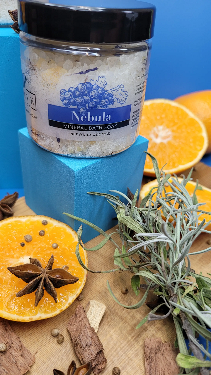 A jar of Mineral Soak - Nebula bath salt featuring a blend of colorful salts and botanical flowers, perfect for a relaxing bath experience.