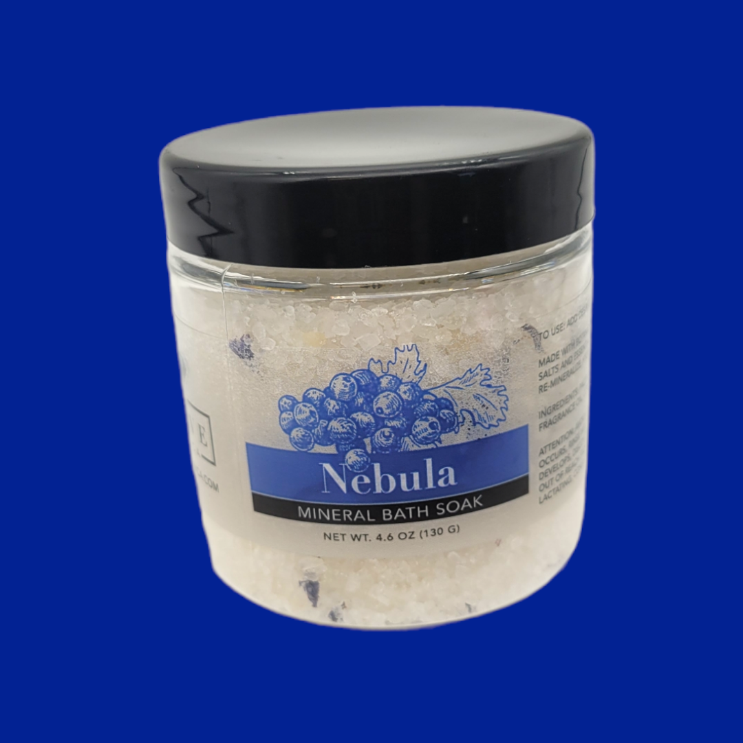 A jar of Mineral Soak - Nebula bath salt featuring a blend of colorful salts and botanical flowers, perfect for a relaxing bath experience.