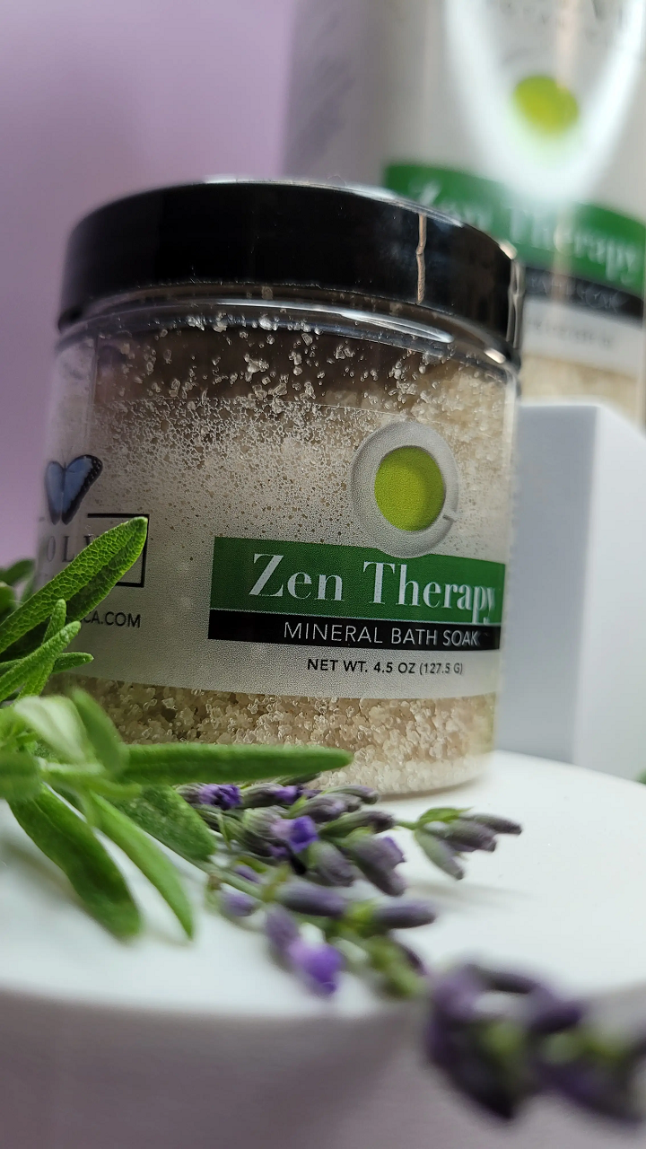 A jar of Mineral Soak - Zen bath salt featuring a blend of dead sea salts, lavender, and rosemary essential oils, surrounded by natural elements.