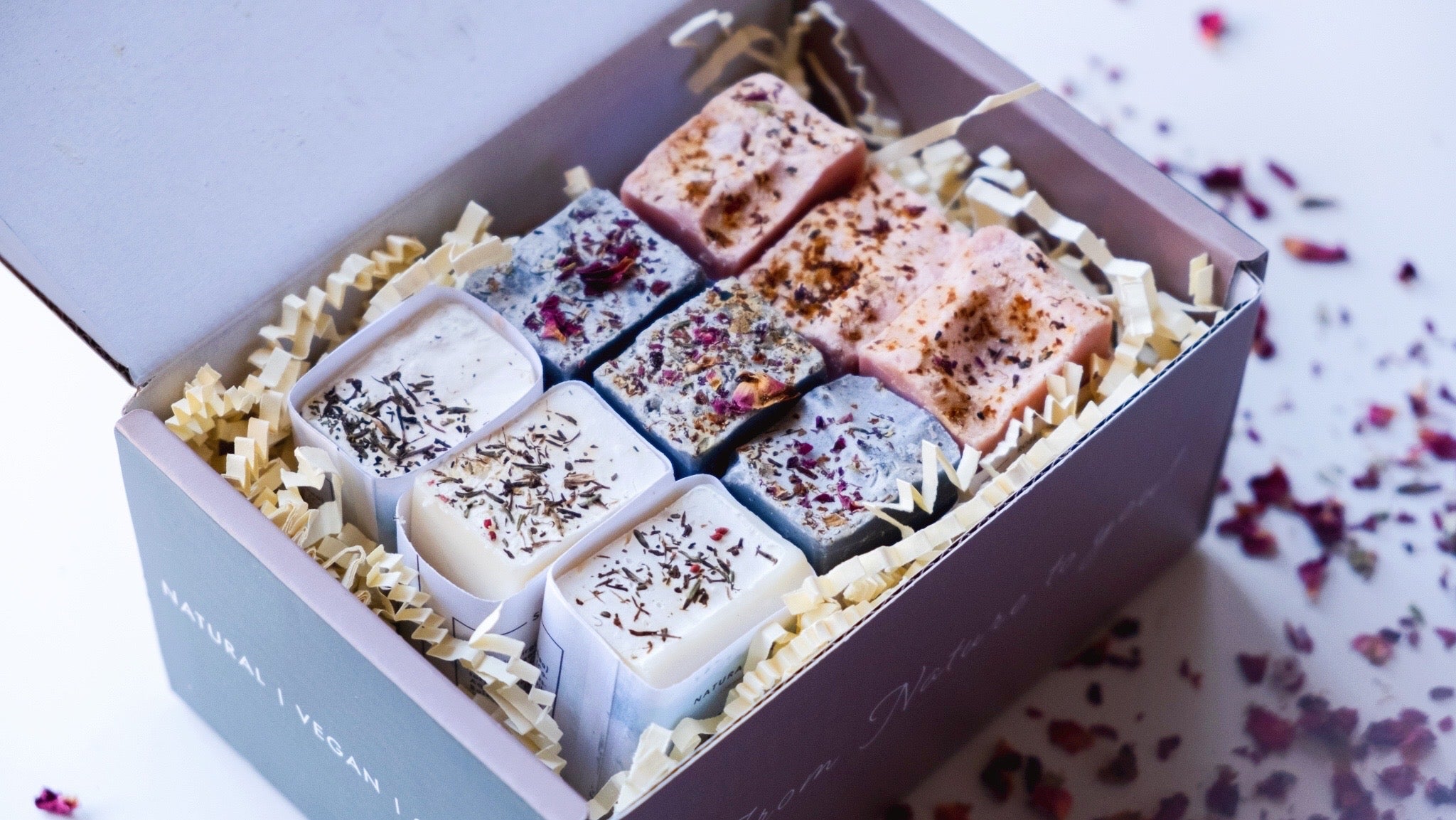 A collection of Mini Soap Bars in various scents, beautifully arranged in a gift box, showcasing their natural ingredients and artisan quality.