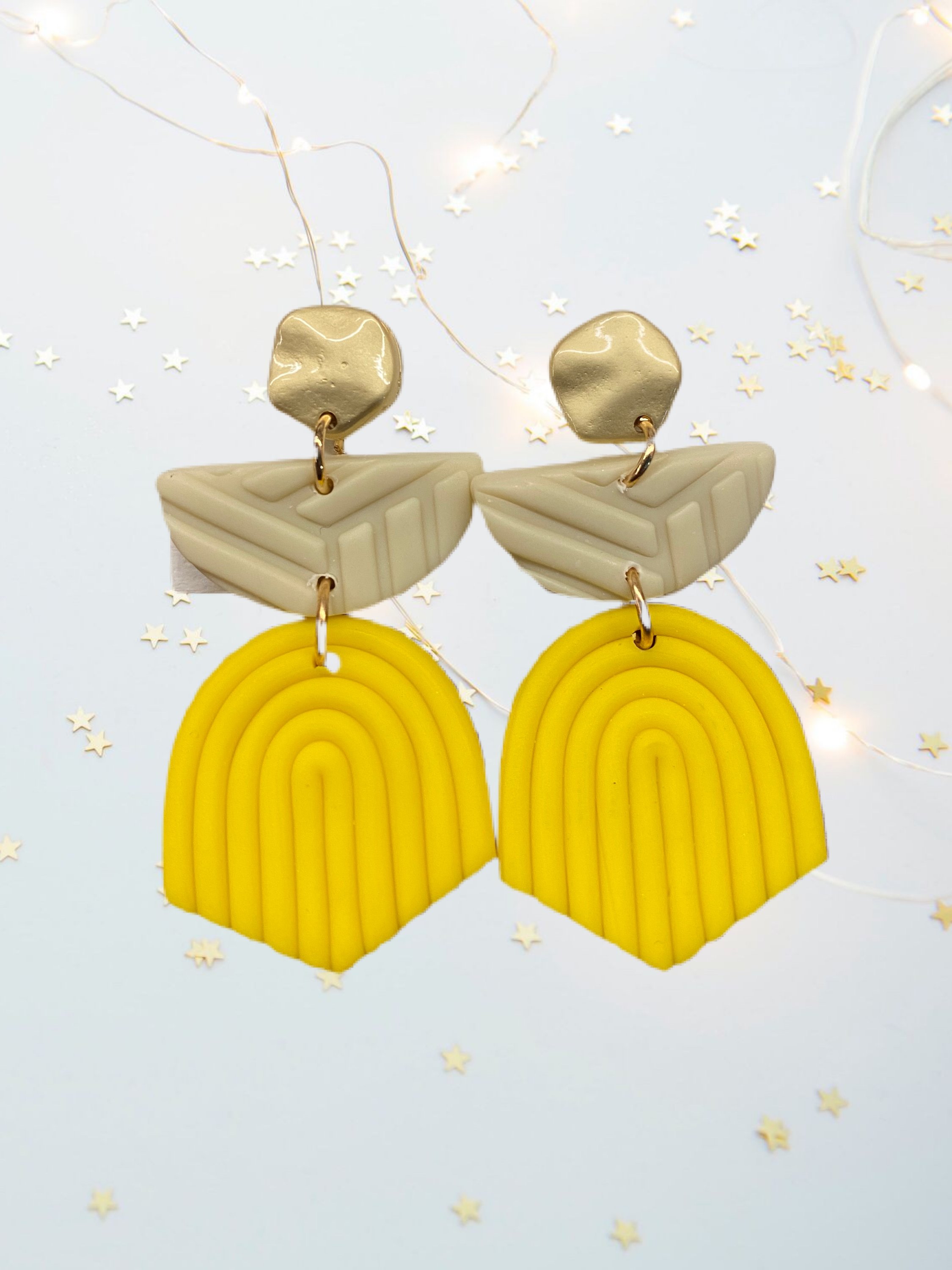 A pair of unique handcrafted modern clay earrings in vibrant colors, showcasing their lightweight and stylish design.