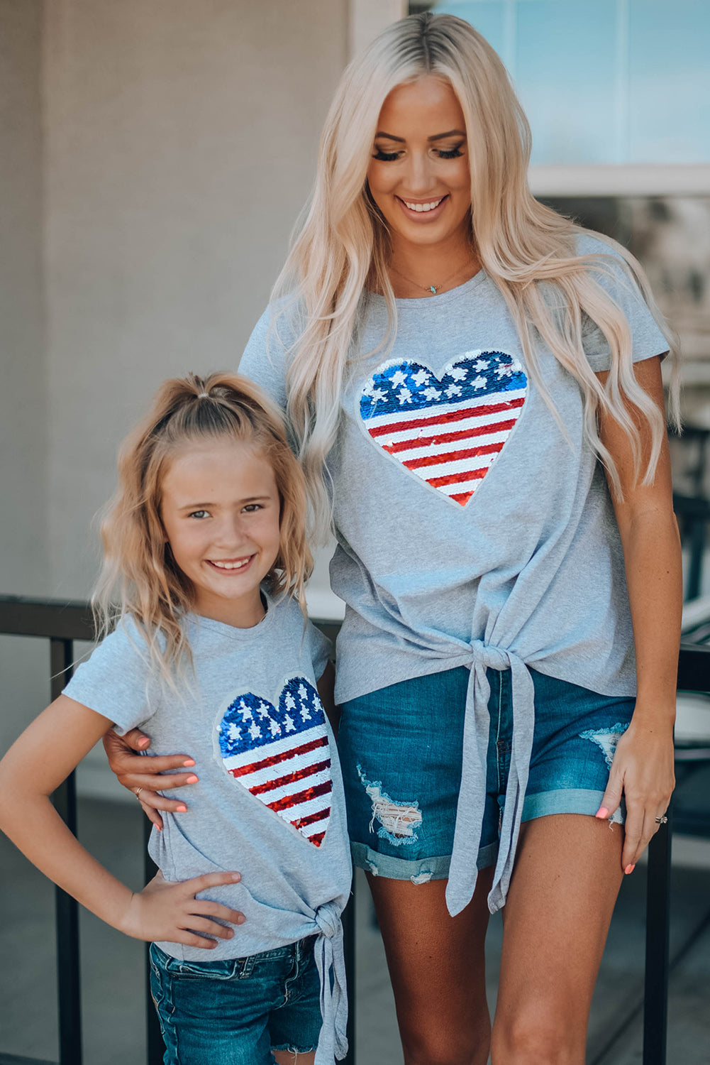 Mommy Patriotic Flag Sequin Heart Applique Knot Top featuring a heart-shaped flag design, soft gray fabric, and stylish knot hem.