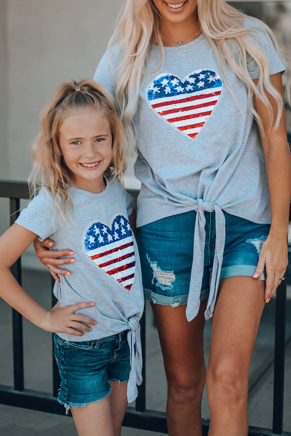 Mommy Patriotic Flag Sequin Heart Applique Knot Top featuring a heart-shaped flag design, soft gray fabric, and stylish knot hem.