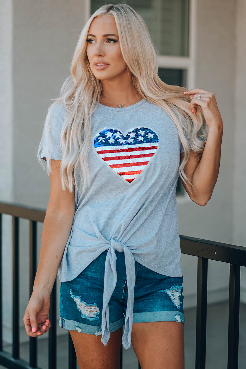 Mommy Patriotic Flag Sequin Heart Applique Knot Top featuring a heart-shaped flag design, soft gray fabric, and stylish knot hem.