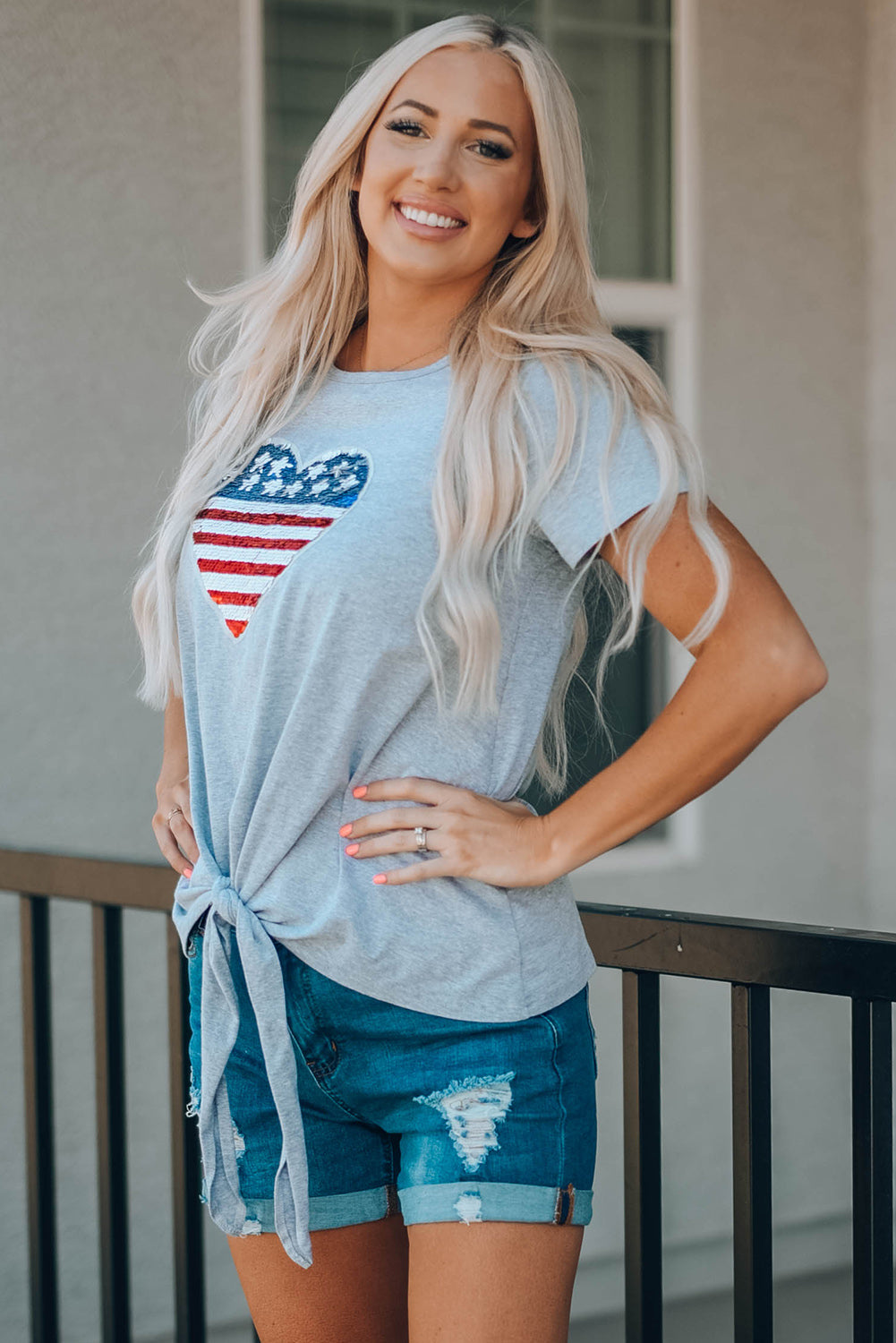 Mommy Patriotic Flag Sequin Heart Applique Knot Top featuring a heart-shaped flag design, soft gray fabric, and stylish knot hem.