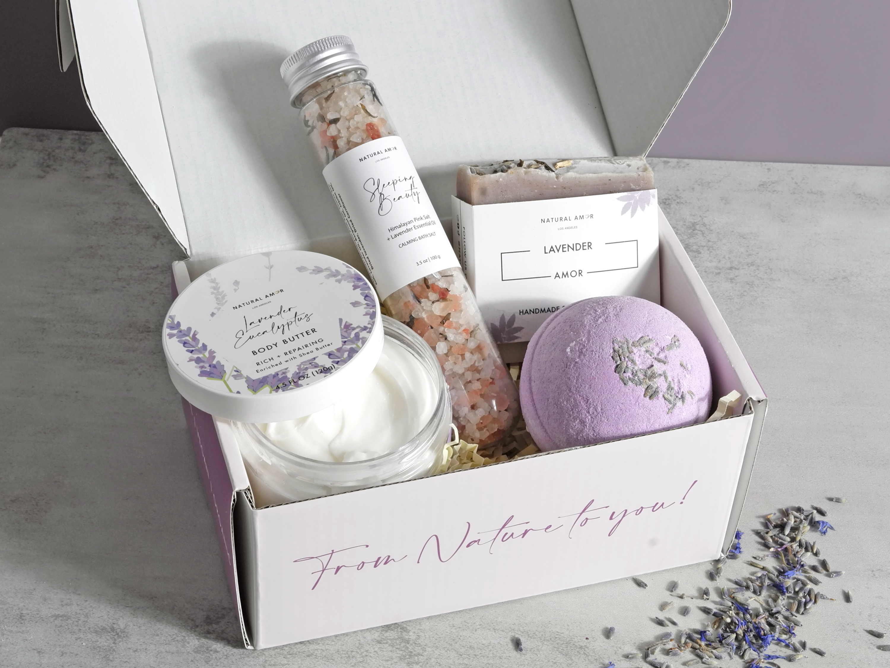 Mother's Embrace gift box featuring vegan skincare products including soap, bath salt, body butter, and bath bomb in rose and lavender scents.