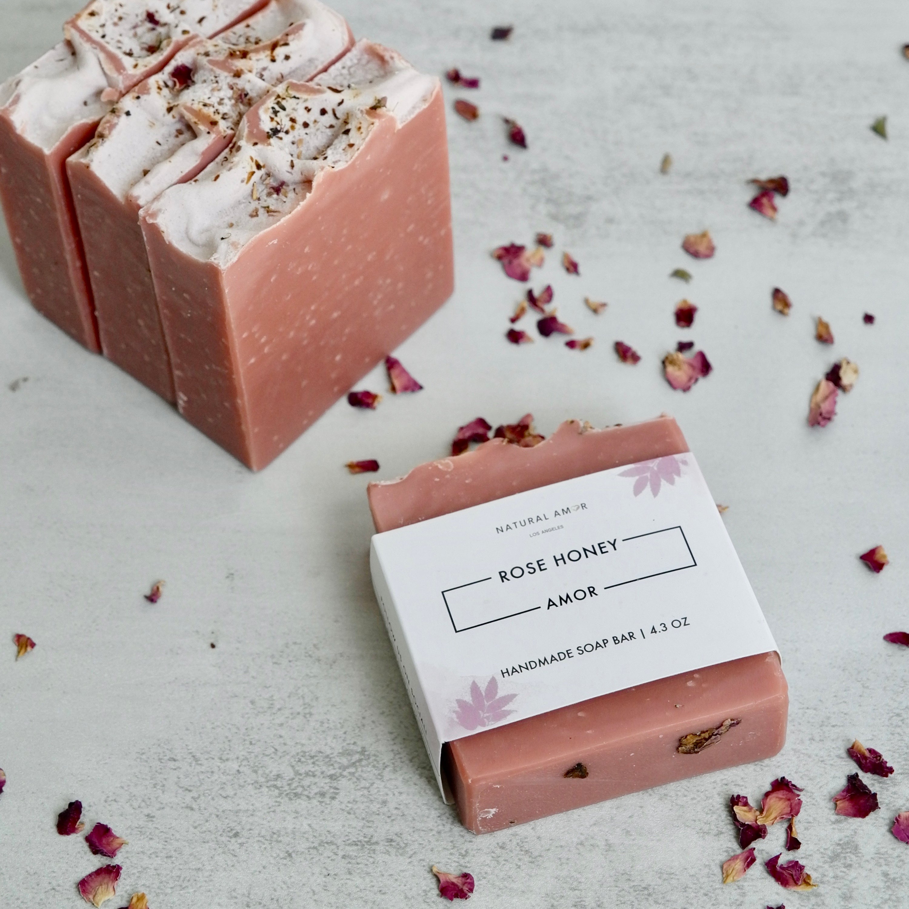 Mother's Embrace gift box featuring vegan skincare products including soap, bath salt, body butter, and bath bomb in rose and lavender scents.