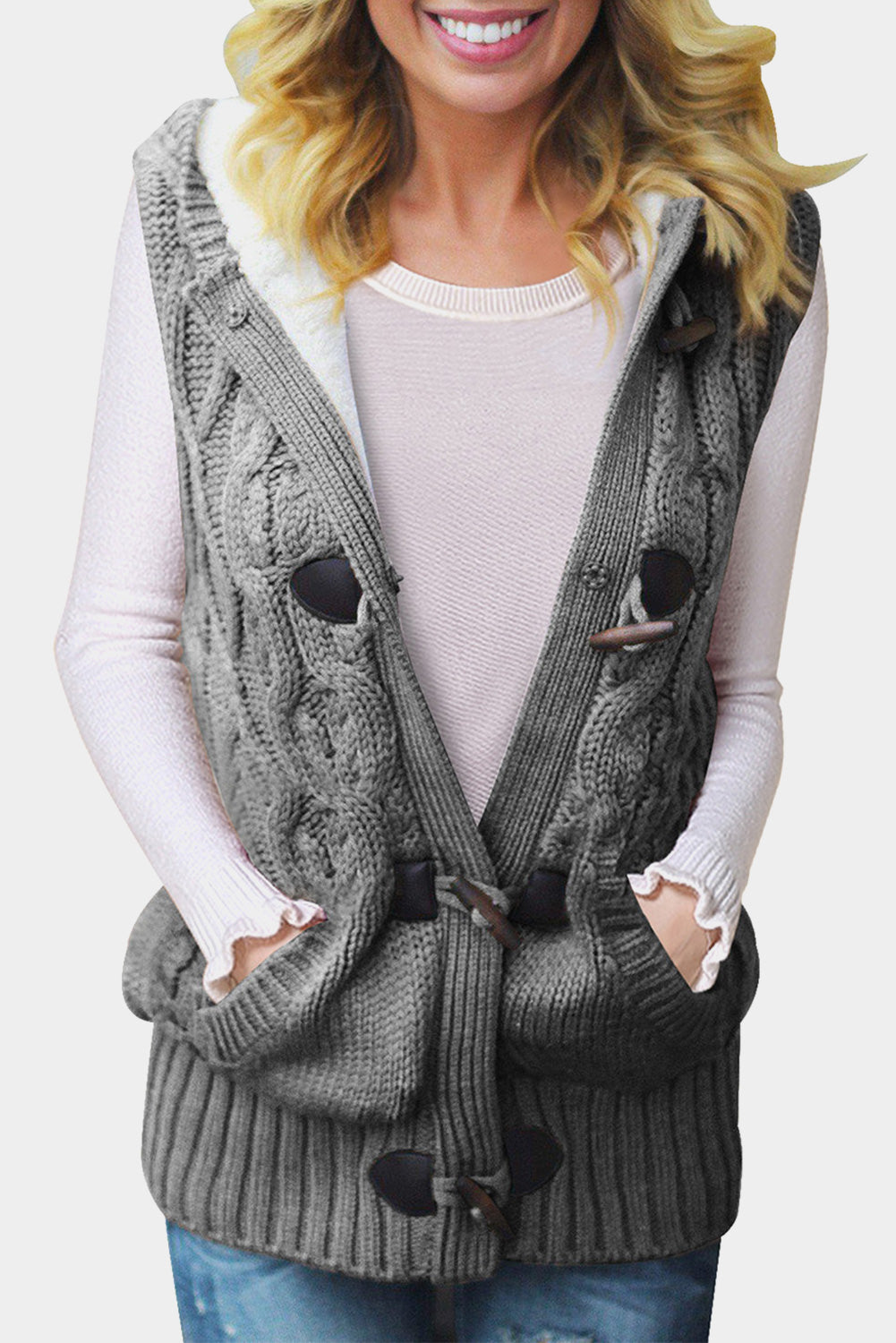 A cozy multicolour cable knit hooded sweater vest with an open front and button-down design, featuring side pockets.