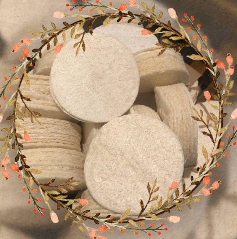 Five natural loofah pads in a pack, showcasing their off-white color and circular shape, ideal for exfoliating skin.