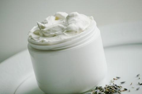 A jar of Natural Shea Whipped Body Butter with a creamy texture, surrounded by natural ingredients like cocoa butter and jojoba oil, showcasing its moisturizing properties.