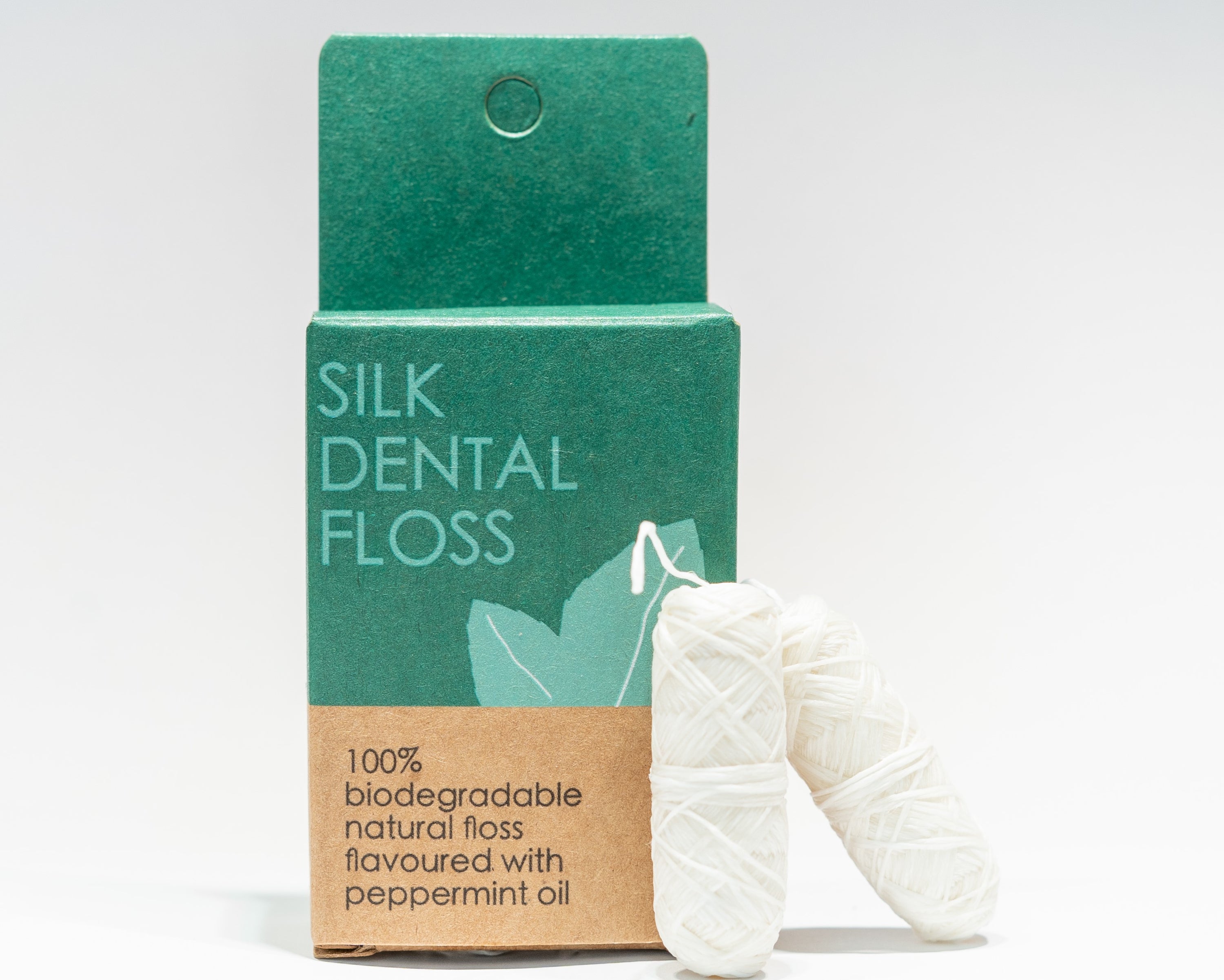 Natural Silk Dental Floss Refill in a glass tube with stainless steel lid, featuring biodegradable silk and peppermint flavor.