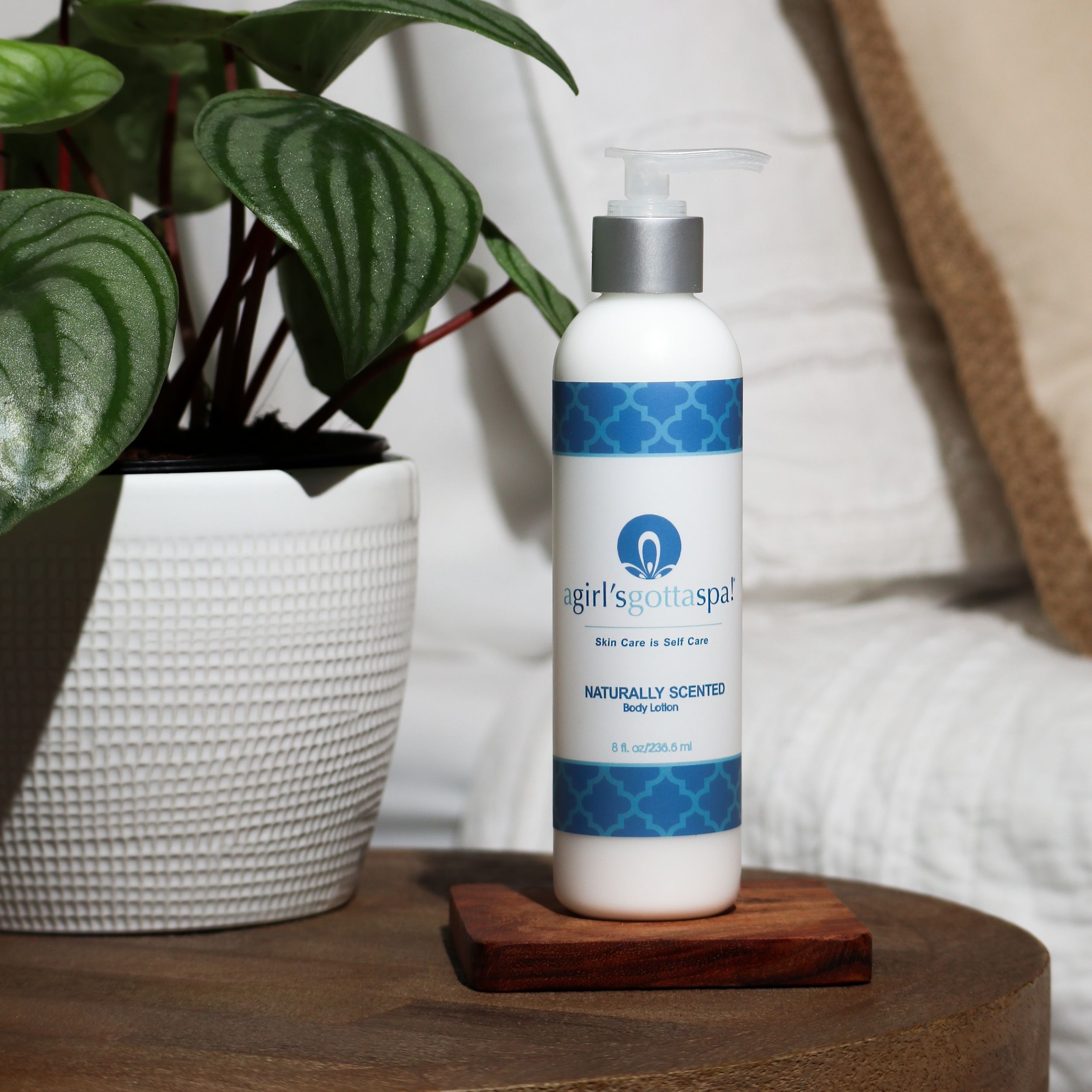 A bottle of Naturally Scented Body Lotion (Unscented) with a creamy texture, showcasing its nourishing ingredients like shea butter and cocoa butter.