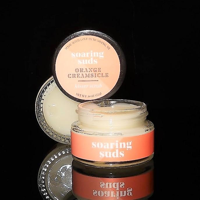 Orange Creamsicle Kisser Scrub in a small jar, showcasing its creamy texture and vibrant orange color, perfect for lip exfoliation.