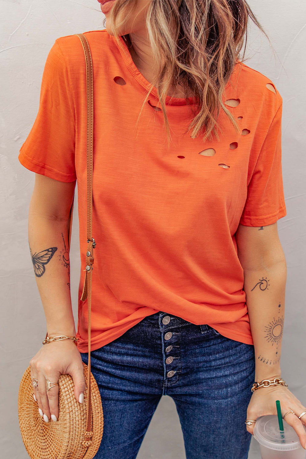 Orange crew neck t-shirt with unique holed design, short sleeves, and soft cotton fabric, perfect for casual wear.