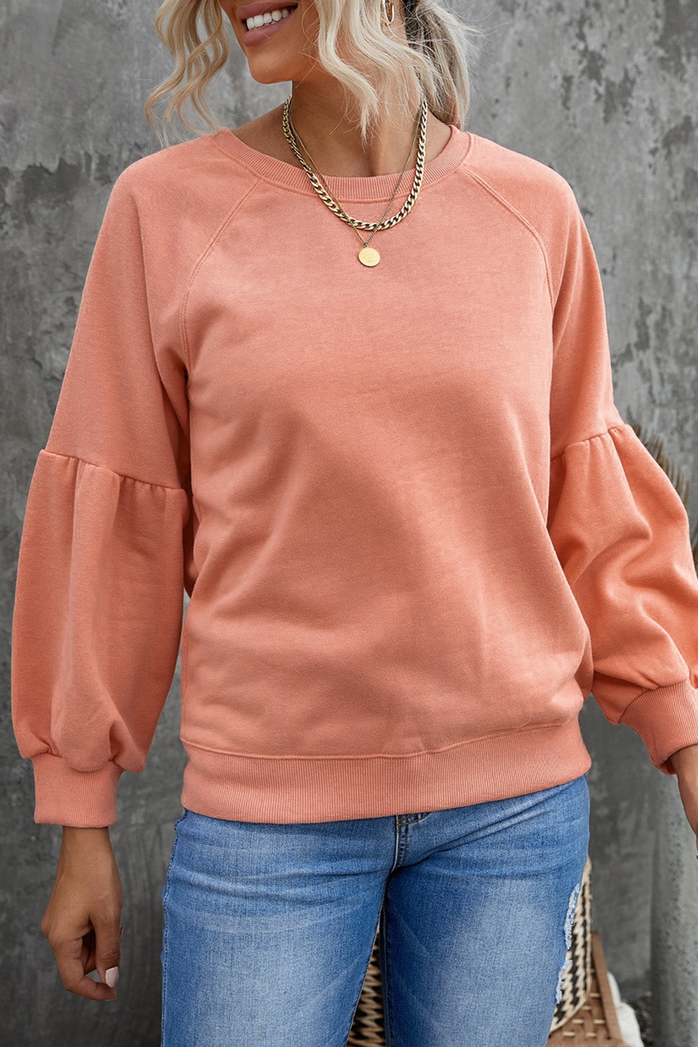 Orange pullover sweatshirt with patchwork raglan sleeves, showcasing a trendy and stylish design suitable for casual wear.