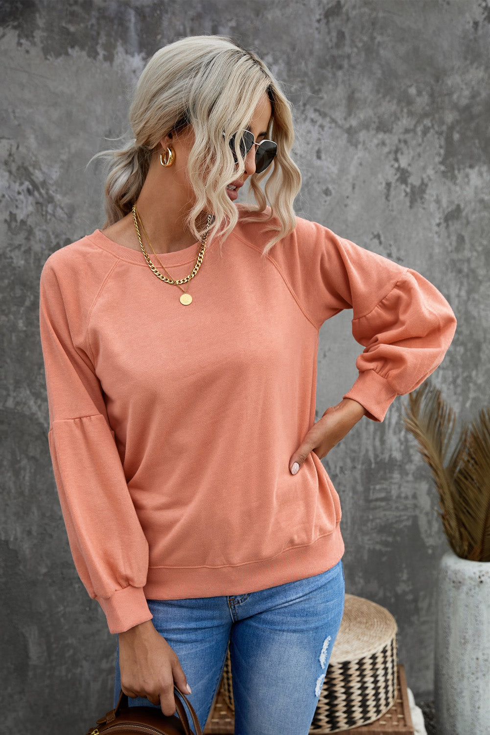 Orange pullover sweatshirt with patchwork raglan sleeves, showcasing a trendy and stylish design suitable for casual wear.