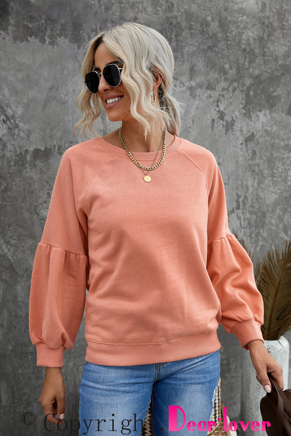 Orange pullover sweatshirt with patchwork raglan sleeves, showcasing a trendy and stylish design suitable for casual wear.