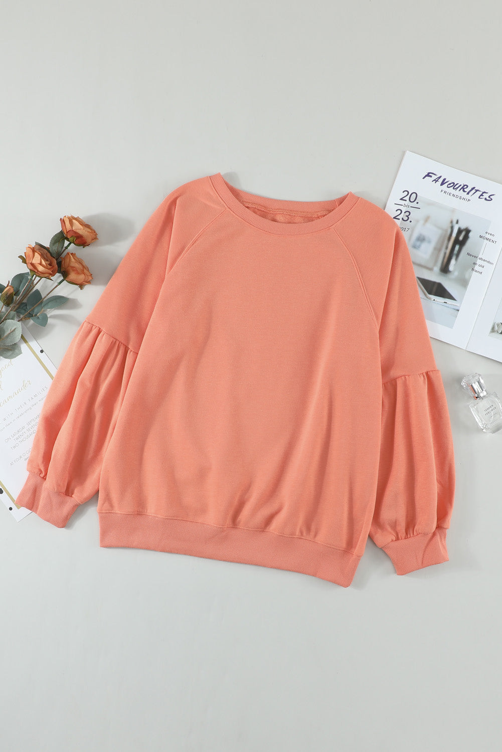 Orange pullover sweatshirt with patchwork raglan sleeves, showcasing a trendy and stylish design suitable for casual wear.