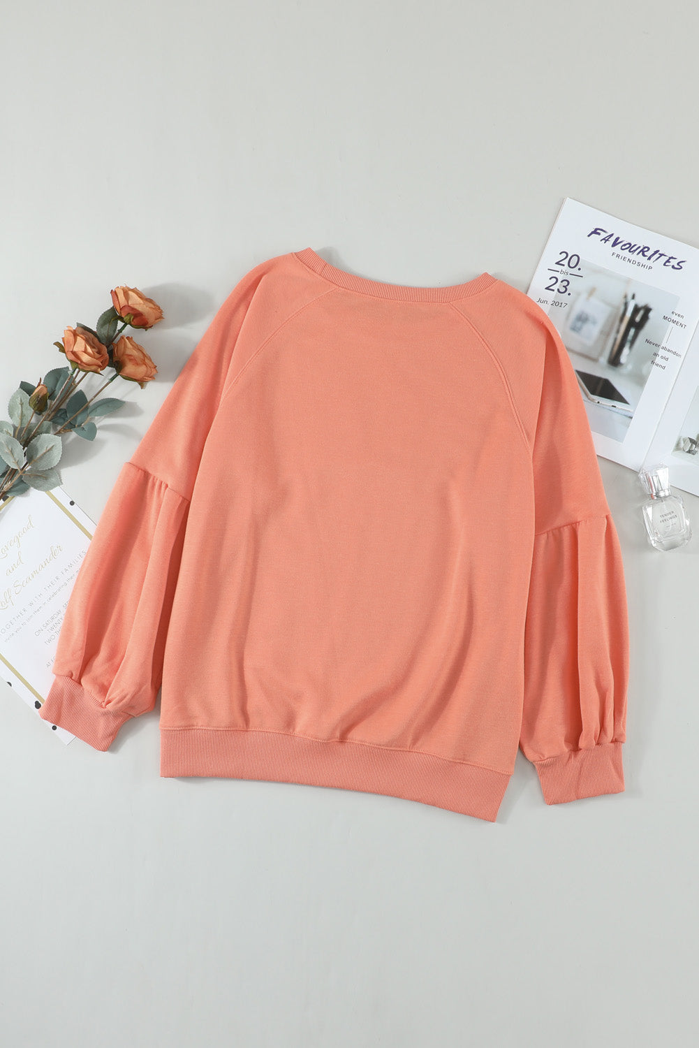 Orange pullover sweatshirt with patchwork raglan sleeves, showcasing a trendy and stylish design suitable for casual wear.