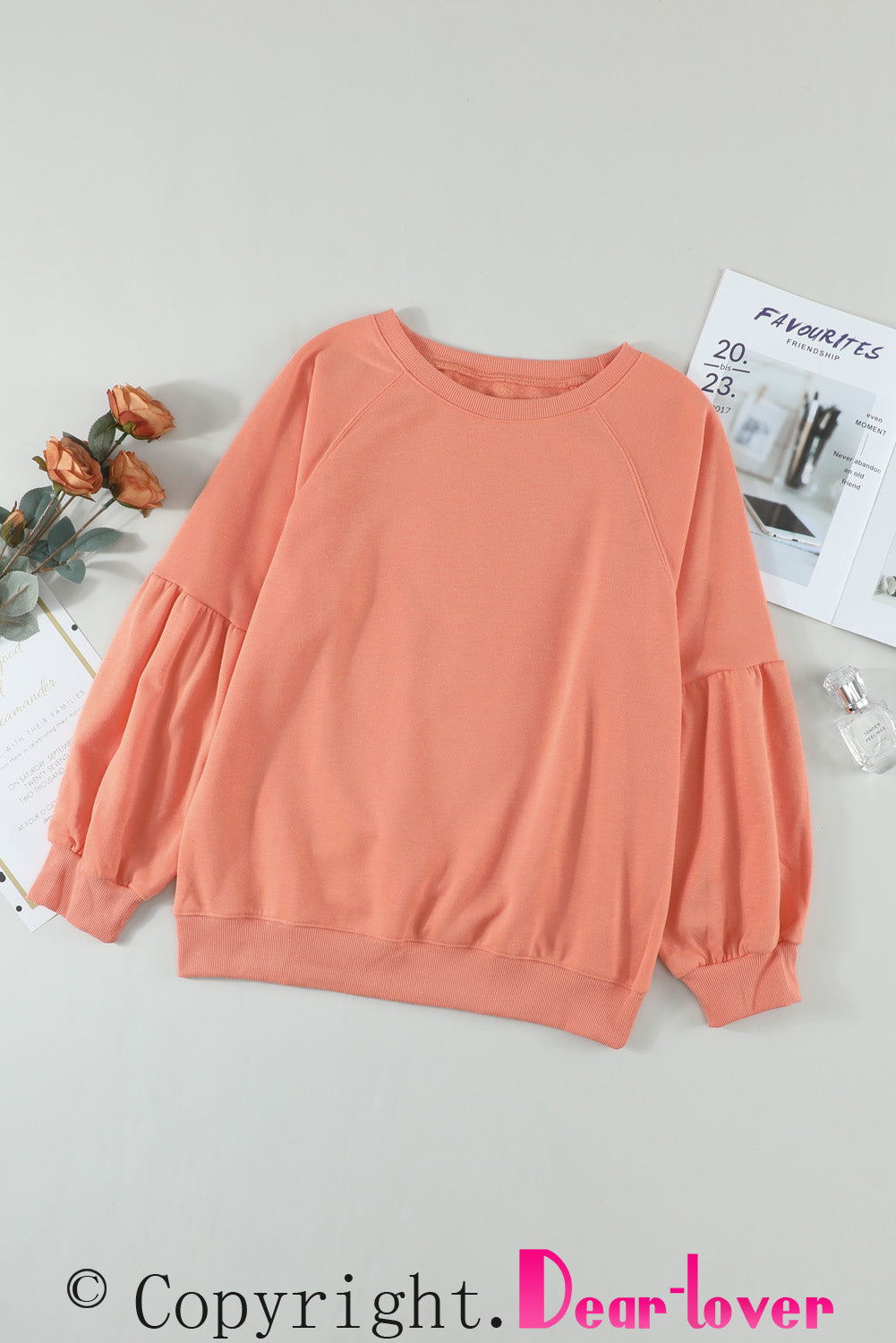 Orange pullover sweatshirt with patchwork raglan sleeves, showcasing a trendy and stylish design suitable for casual wear.