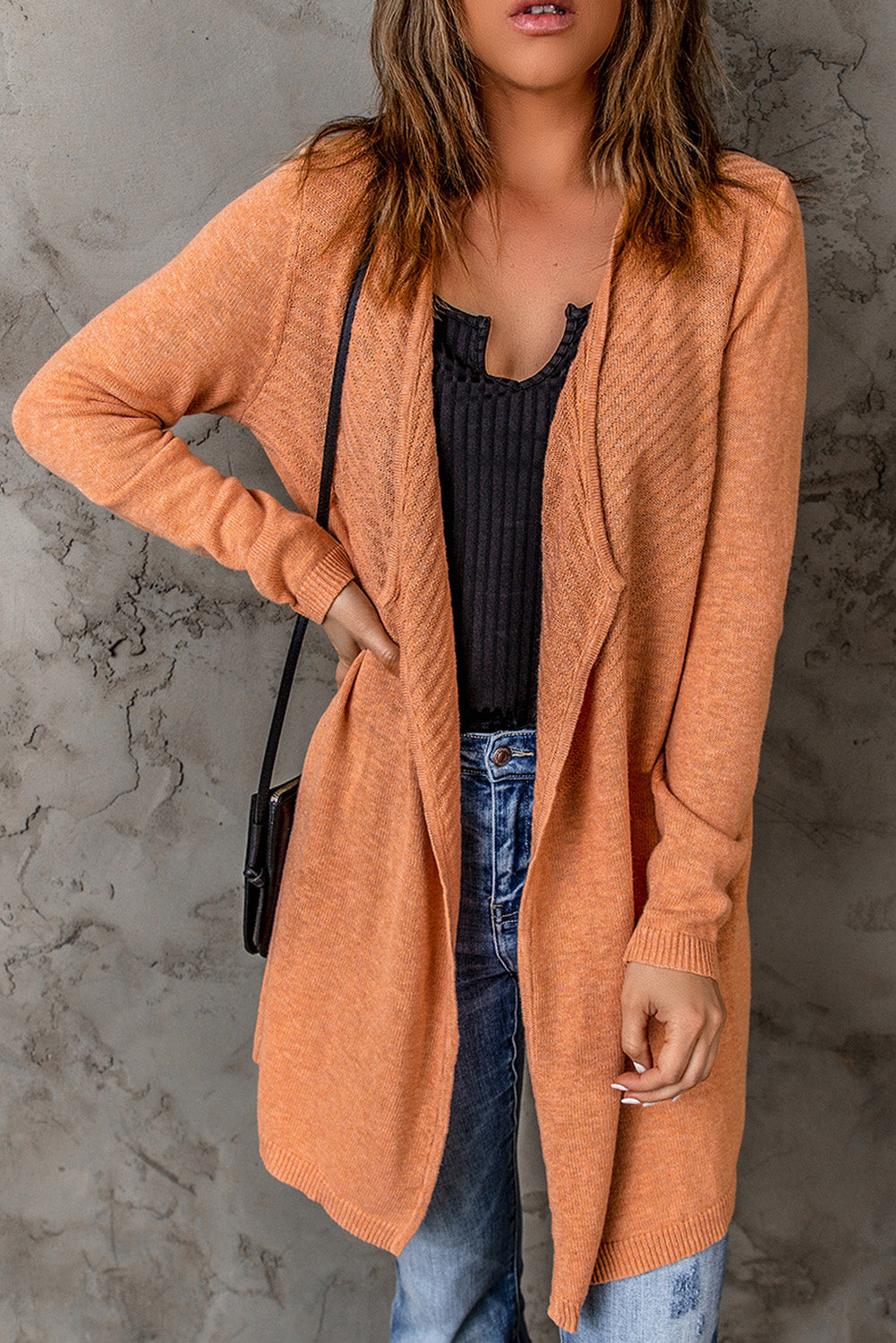 A vibrant orange ribbed open front knit cardigan displayed on a mannequin, showcasing its long sleeves and casual style.