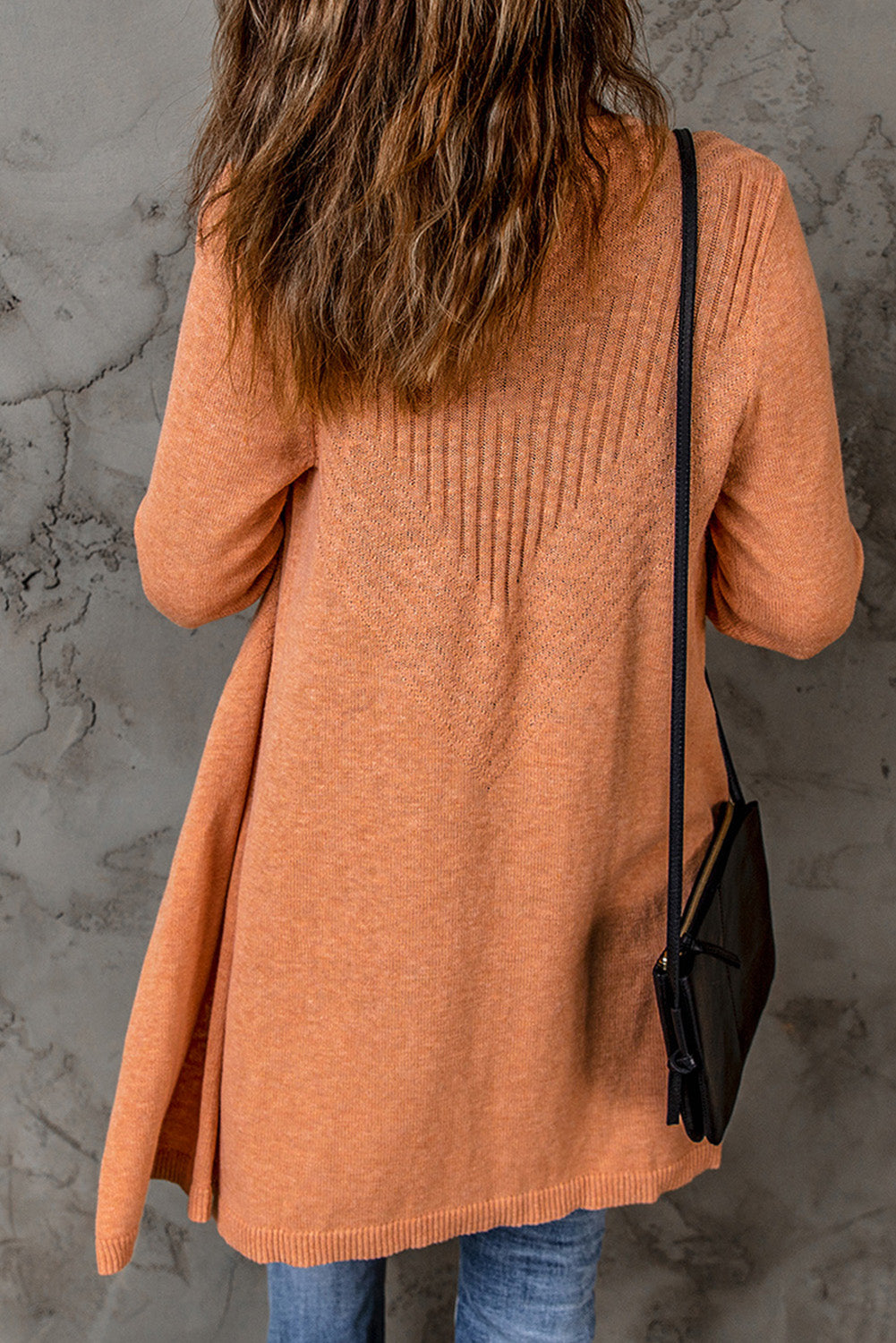 A vibrant orange ribbed open front knit cardigan displayed on a mannequin, showcasing its long sleeves and casual style.