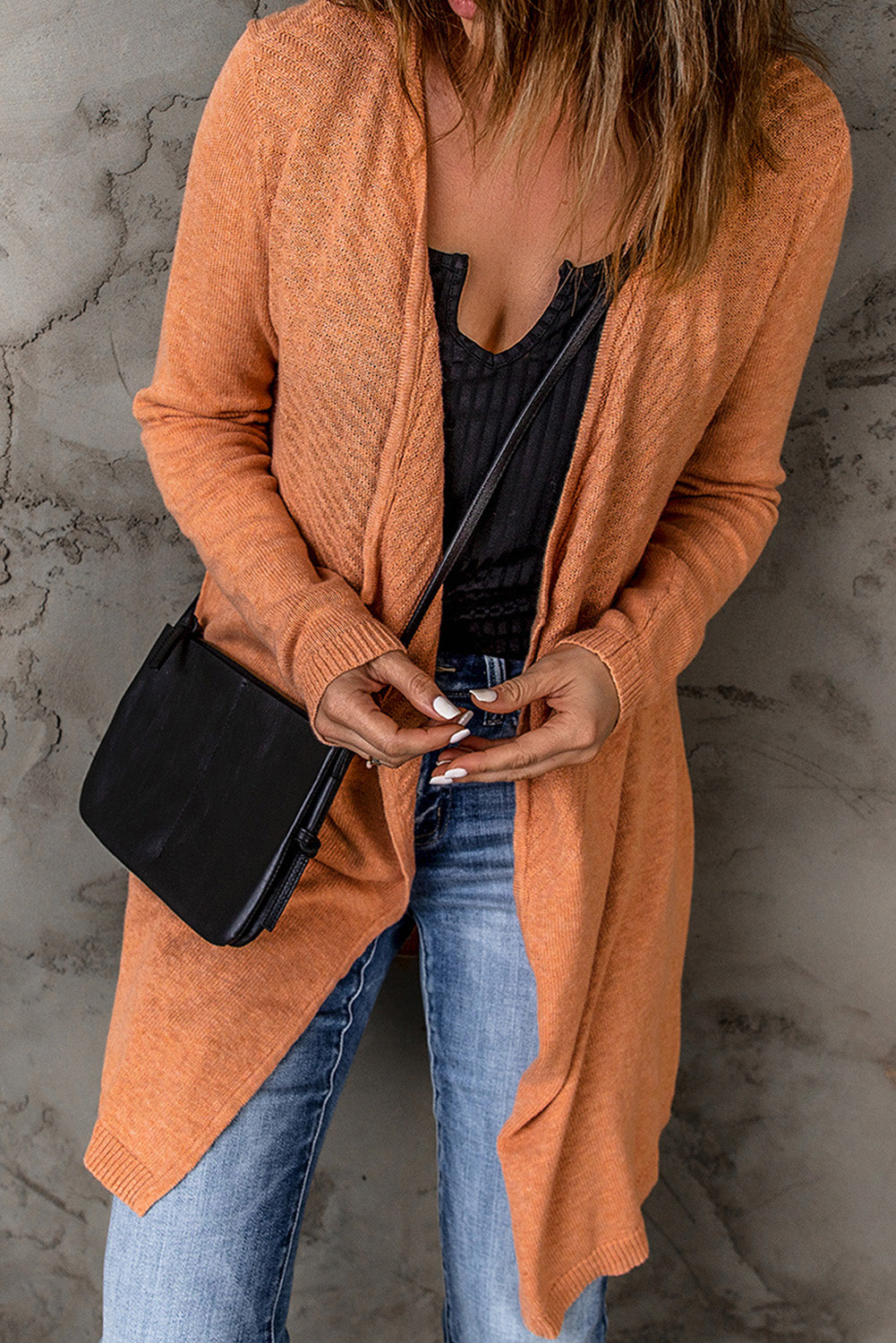 A vibrant orange ribbed open front knit cardigan displayed on a mannequin, showcasing its long sleeves and casual style.