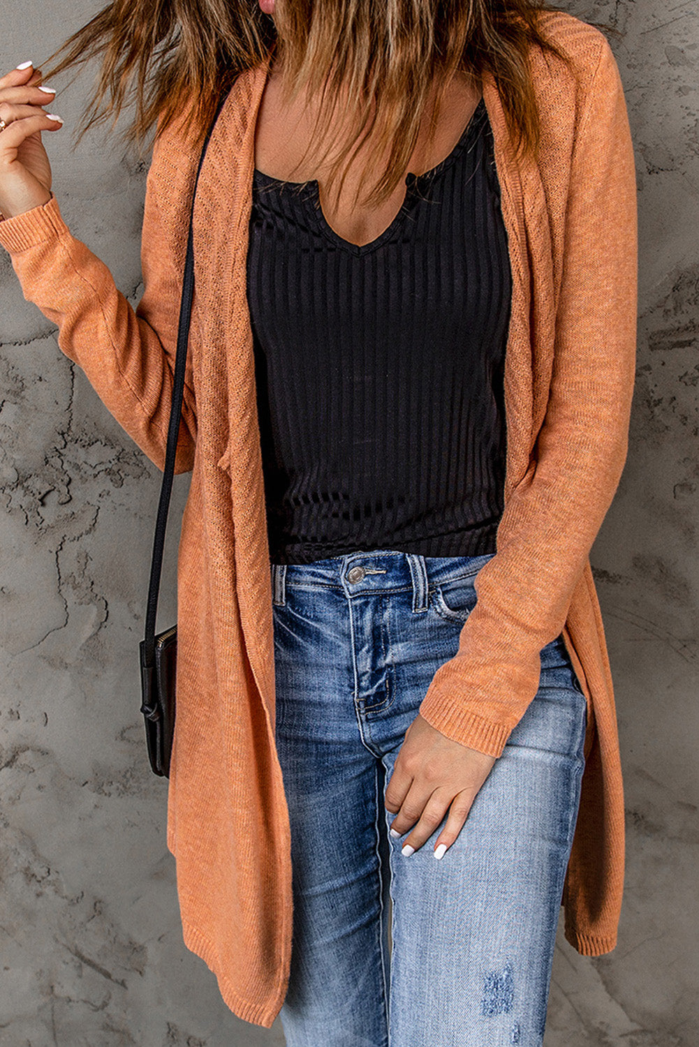 A vibrant orange ribbed open front knit cardigan displayed on a mannequin, showcasing its long sleeves and casual style.