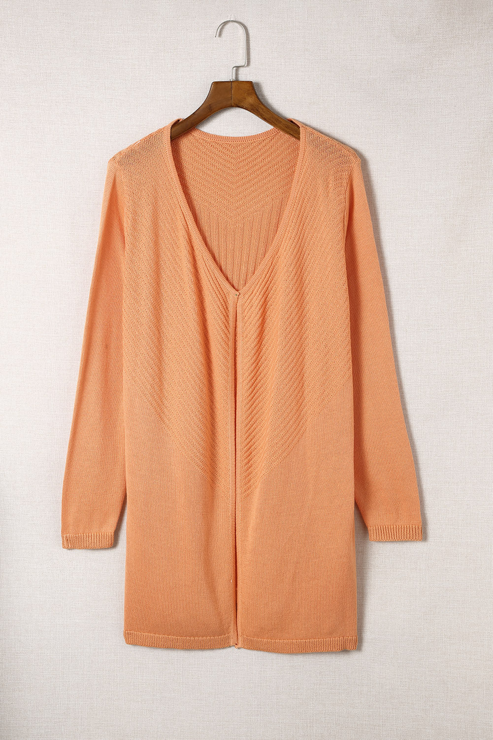 A vibrant orange ribbed open front knit cardigan displayed on a mannequin, showcasing its long sleeves and casual style.