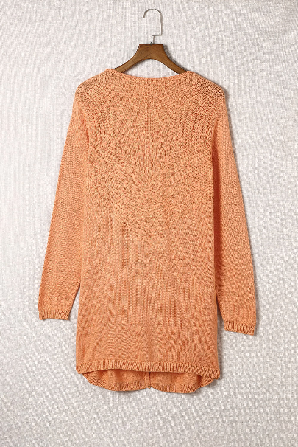 A vibrant orange ribbed open front knit cardigan displayed on a mannequin, showcasing its long sleeves and casual style.