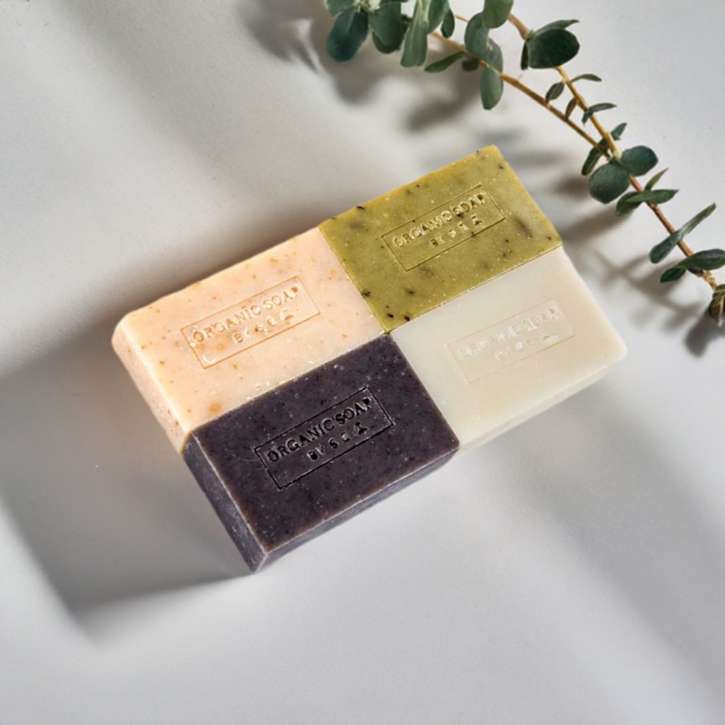 A collection of organic bar soaps in various scents, showcasing their natural ingredients and eco-friendly packaging.