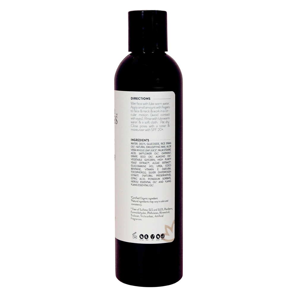 A bottle of Organic Skin Renewal Gentle Cleanser with a soothing label, designed for sensitive skin, placed on a marble countertop surrounded by natural elements.