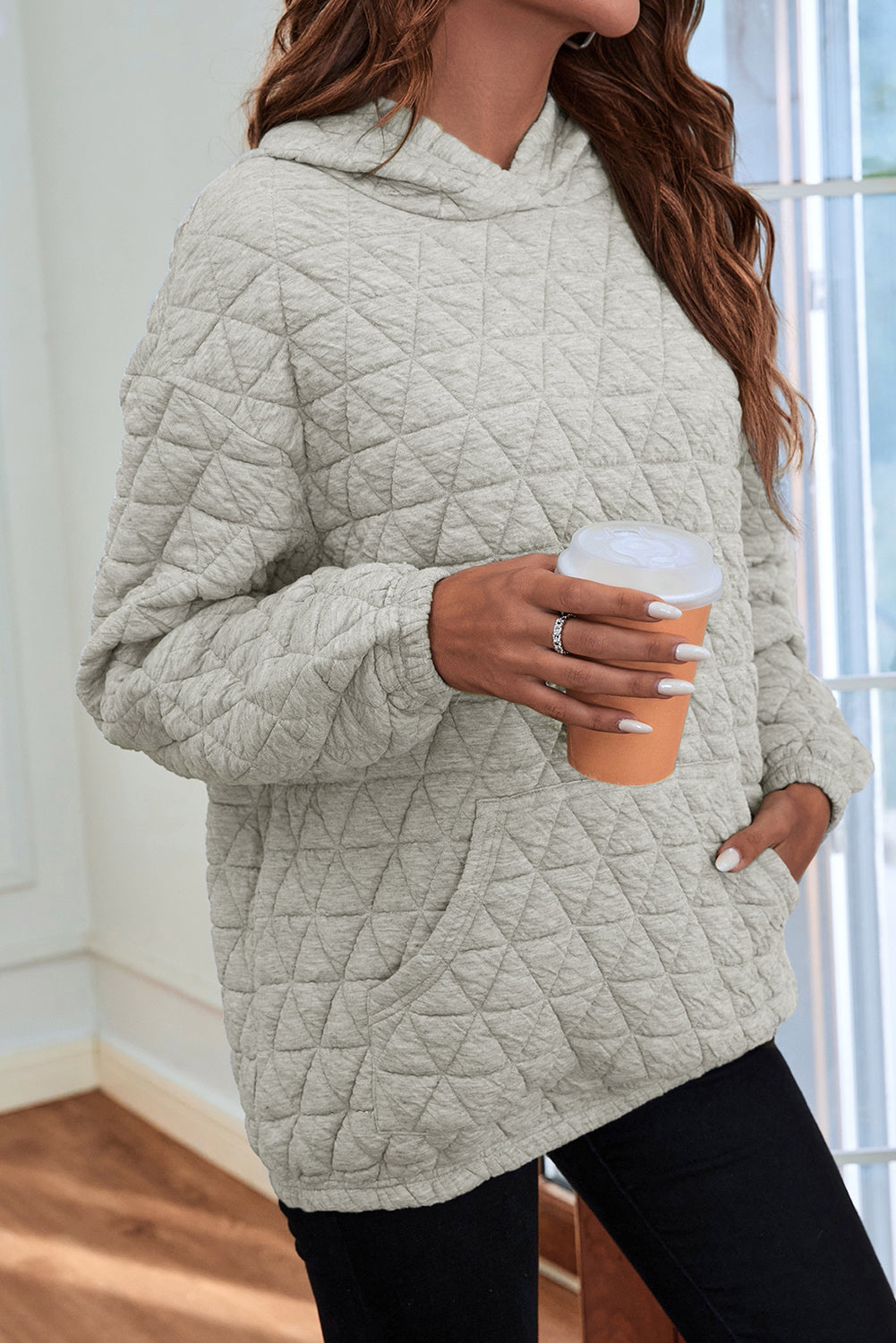 Pale khaki solid color quilted kangaroo pocket hoodie displayed on a mannequin, showcasing its stylish design and functional features.