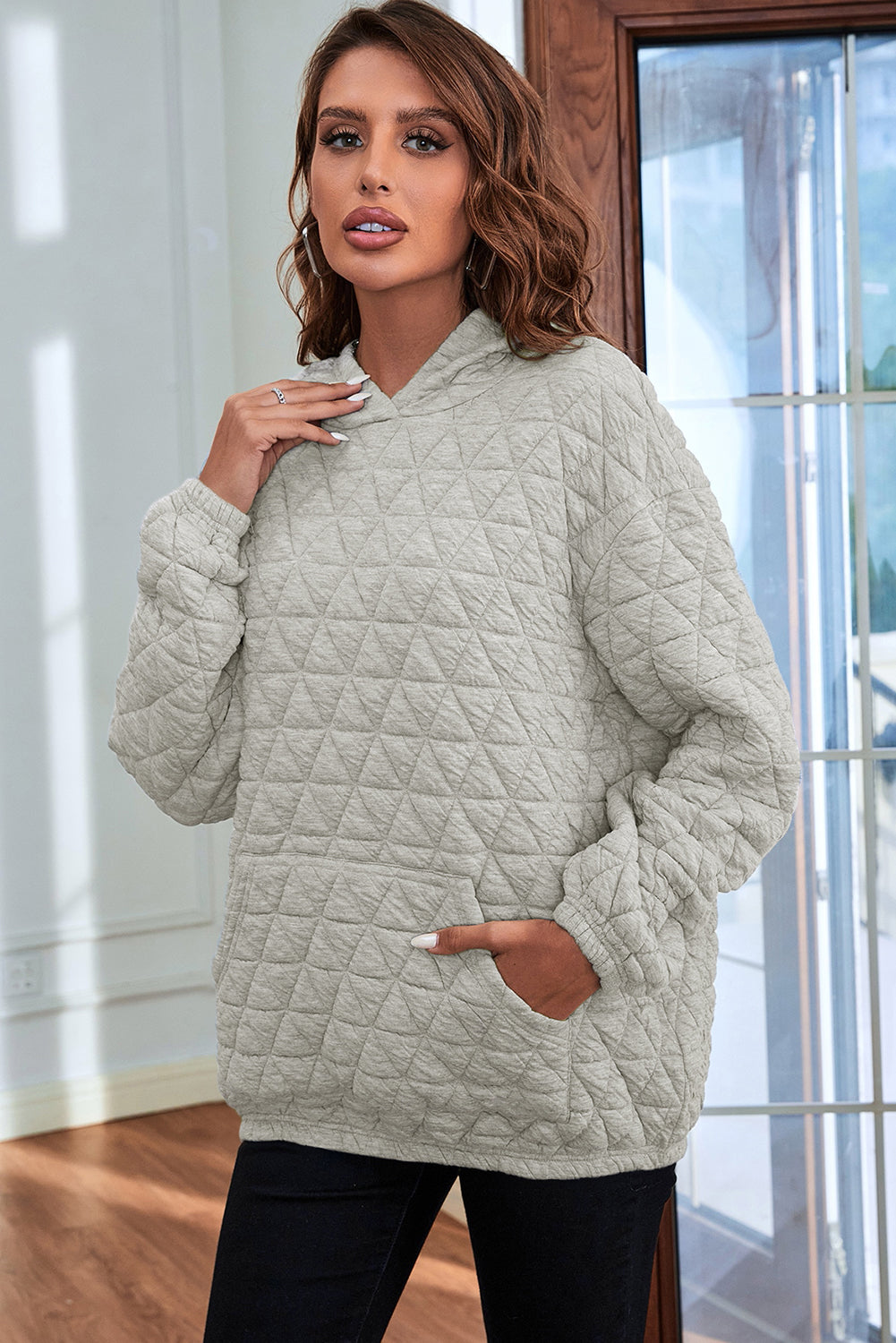 Pale khaki solid color quilted kangaroo pocket hoodie displayed on a mannequin, showcasing its stylish design and functional features.