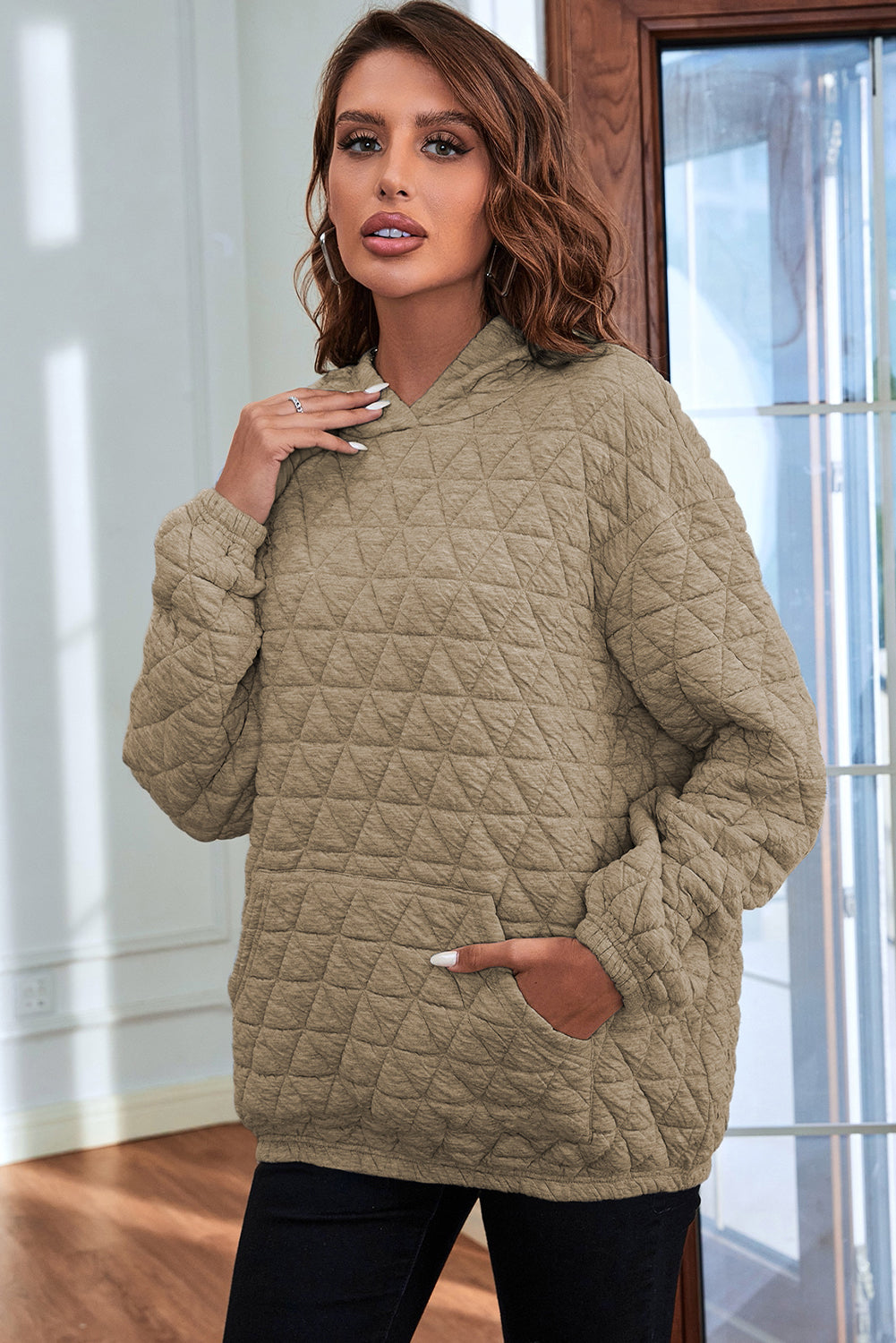 Pale khaki solid color quilted kangaroo pocket hoodie displayed on a mannequin, showcasing its stylish design and functional features.