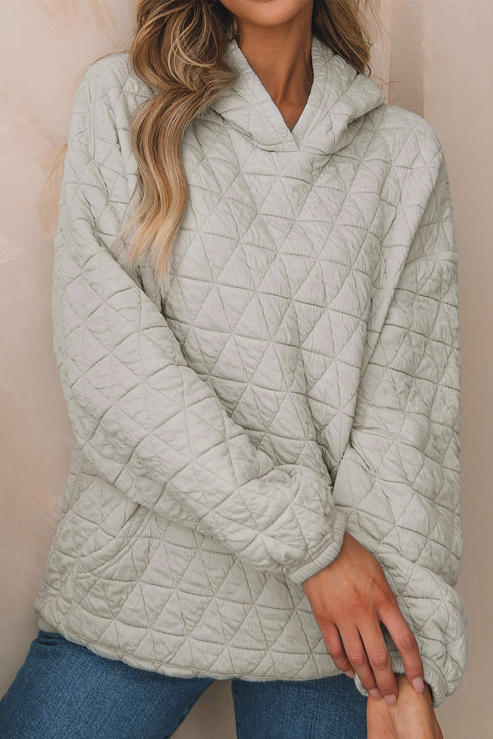 Pale khaki solid color quilted kangaroo pocket hoodie displayed on a mannequin, showcasing its stylish design and functional features.