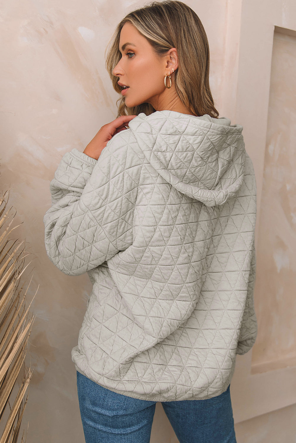 Pale khaki solid color quilted kangaroo pocket hoodie displayed on a mannequin, showcasing its stylish design and functional features.