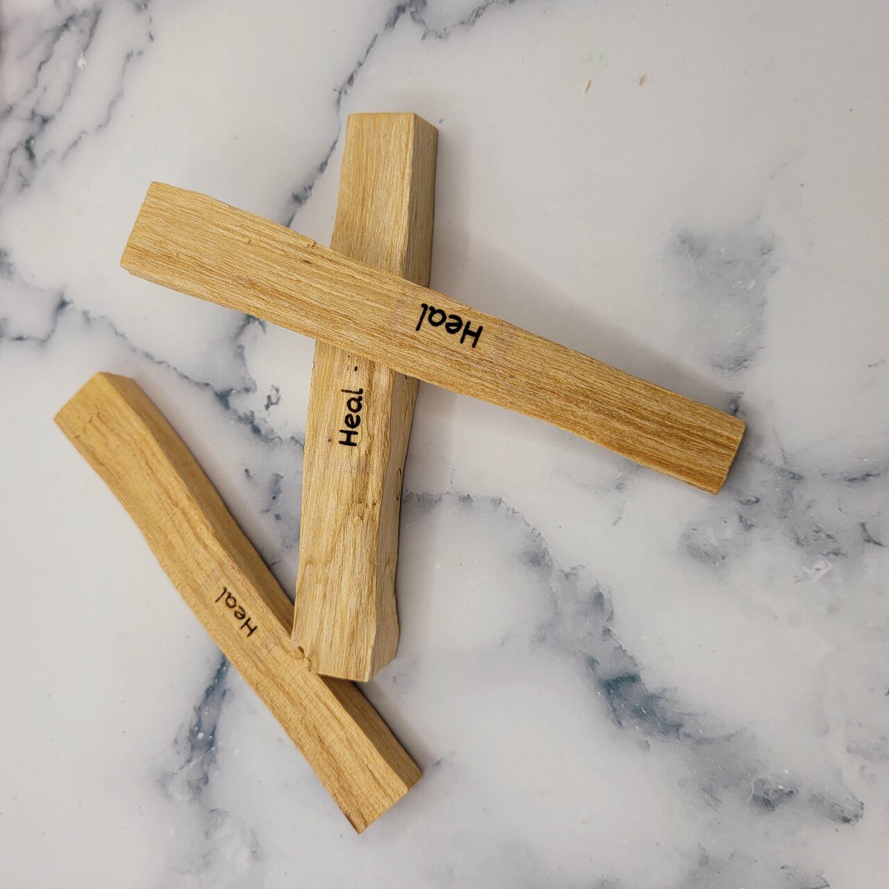 A bundle of sustainably harvested Palo Santo sticks, each laser engraved with unique designs, ideal for smudging and healing rituals.