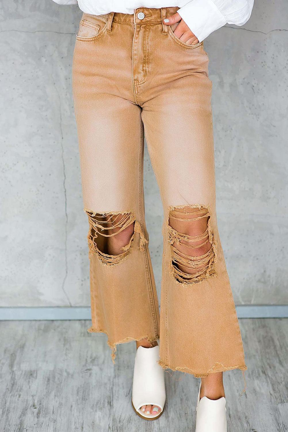 A pair of Peach Blossom Distressed Hollow-out High Waist Cropped Flare Jeans showcasing a vintage style with unique distressed details.