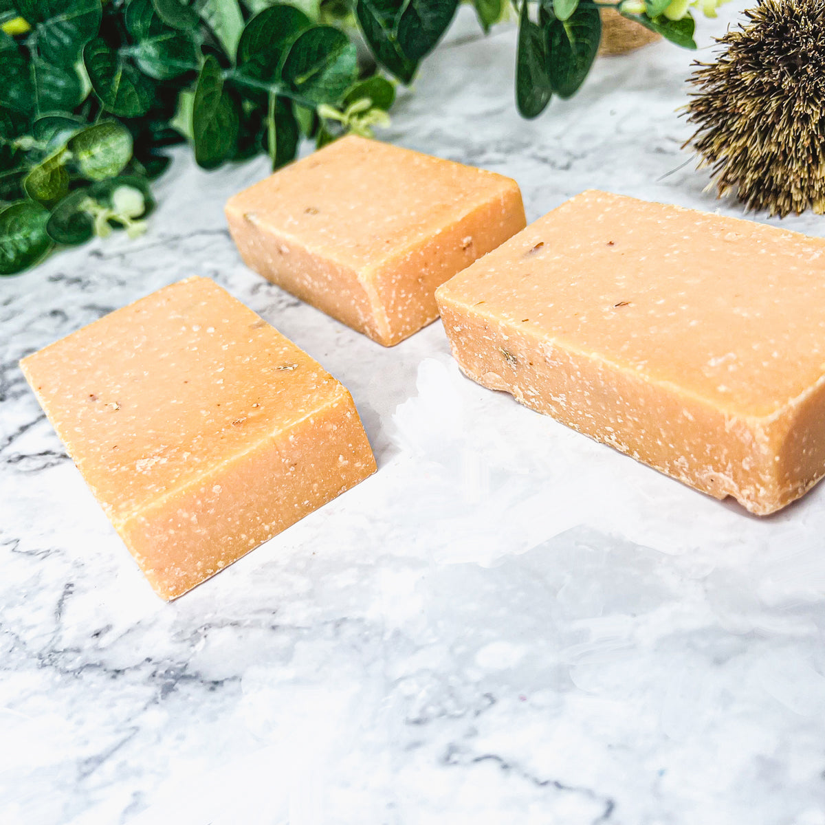 A vibrant Peach Tea Scrub soap bar with a sweet peach fragrance, featuring a unique handmade design and gentle exfoliating properties.