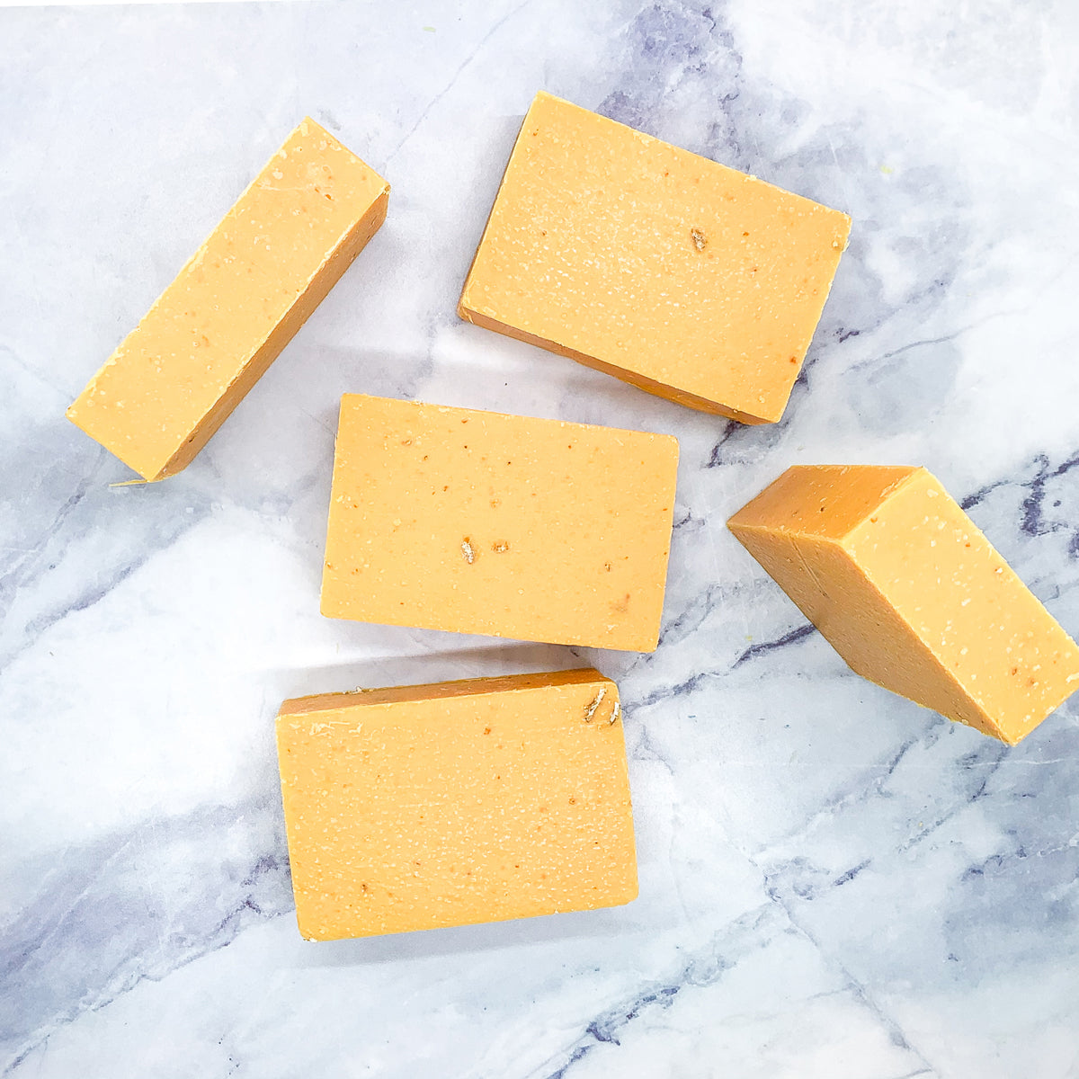 A vibrant Peach Tea Scrub soap bar with a sweet peach fragrance, featuring a unique handmade design and gentle exfoliating properties.