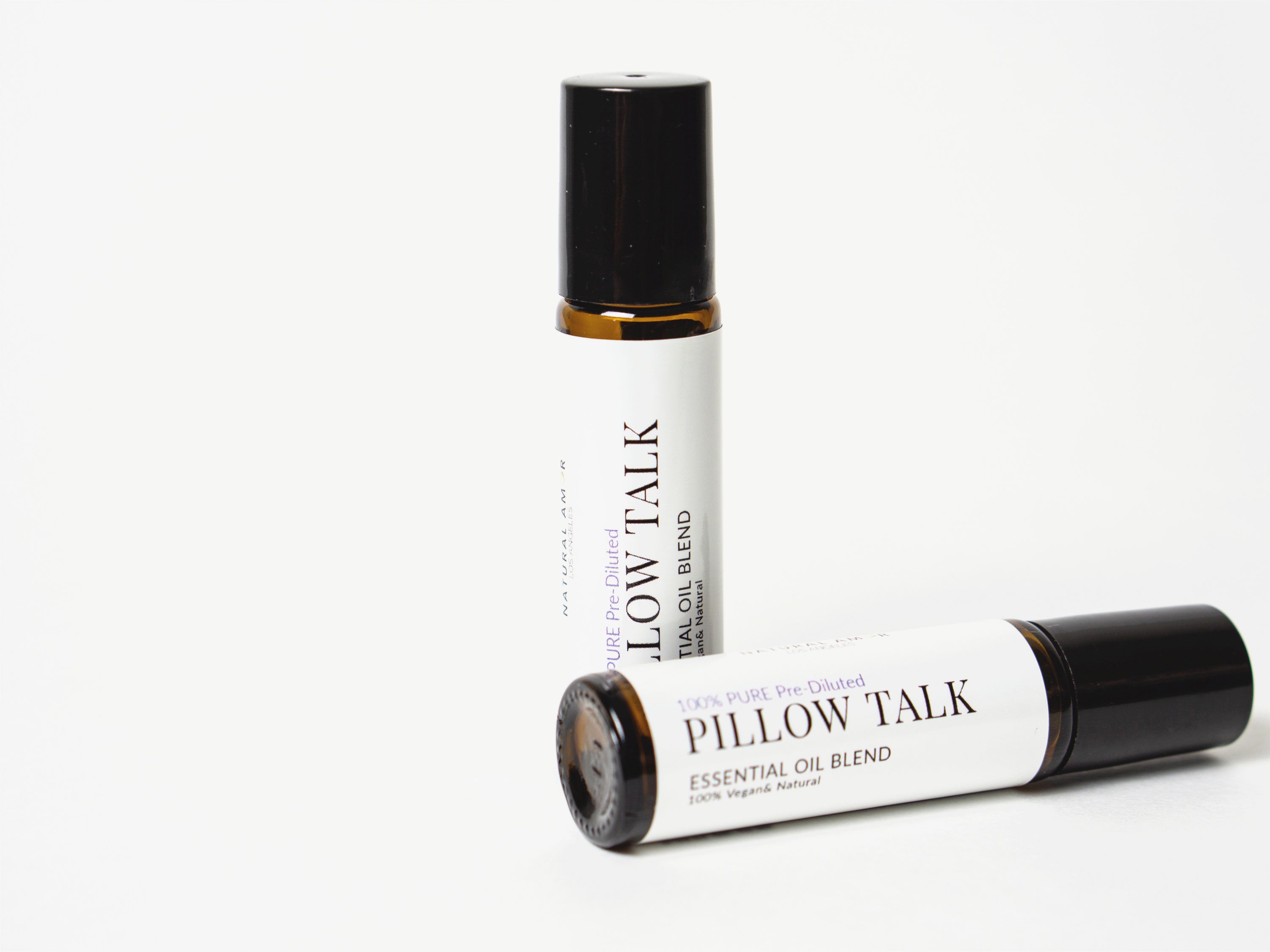 Pillow Talk Roll On Essential Oil Blend in a 10 mL bottle with a stainless steel rollerball, featuring a calming lavender and woodsy design.