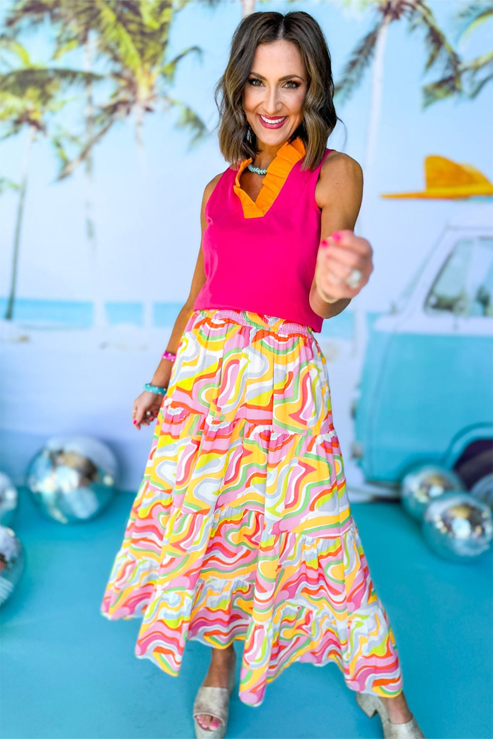 A flowy maxi skirt featuring a vibrant pink abstract print, showcasing a tiered design that adds elegance and movement.