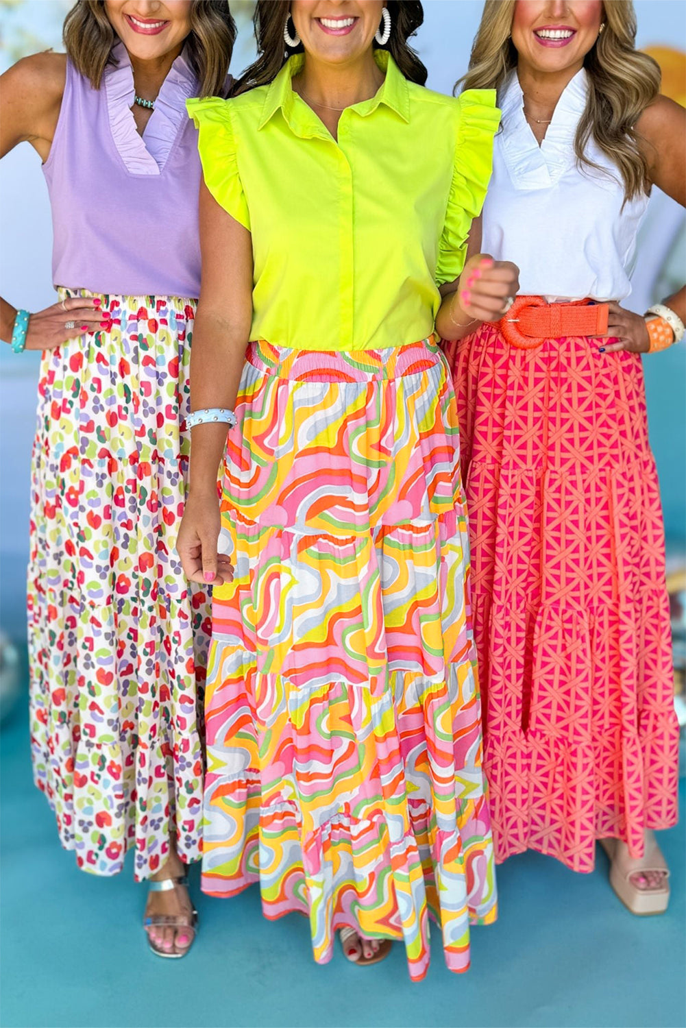 A flowy maxi skirt featuring a vibrant pink abstract print, showcasing a tiered design that adds elegance and movement.