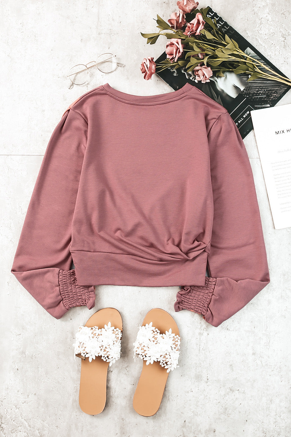 A stylish pink long sleeve crop top with banded hem and smocking cuffs, perfect for casual wear.